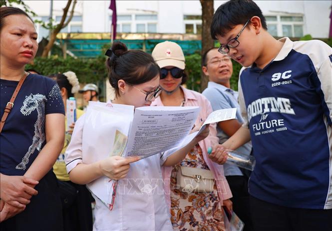 Thí sinh trao đổi về bài làm sau khi hoàn thành môn thi Ngoại ngữ tại điểm thi Trường THCS Lê Ngọc Hân. Ảnh: Thanh Tùng - TTXVN